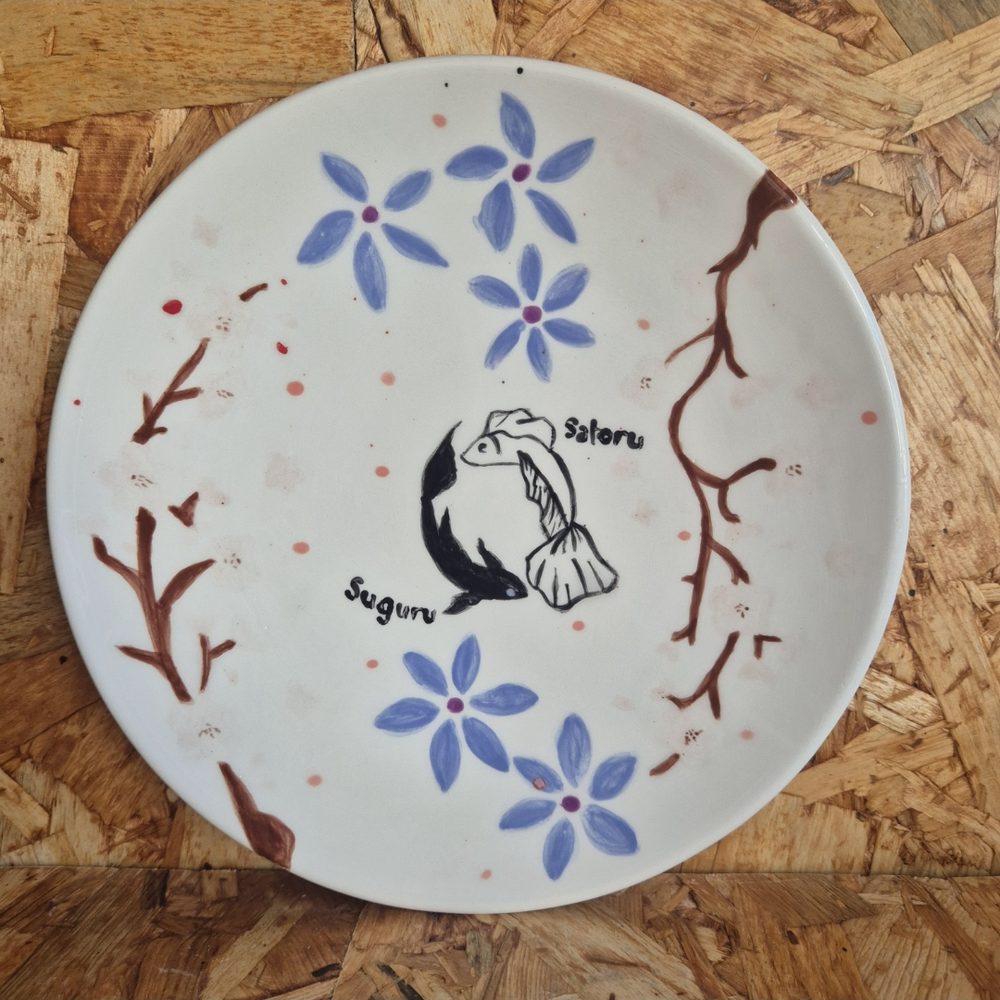 Plate painted with koi fish and blossoms